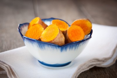 Sliced turmeric roots in blue-rimmed bowl